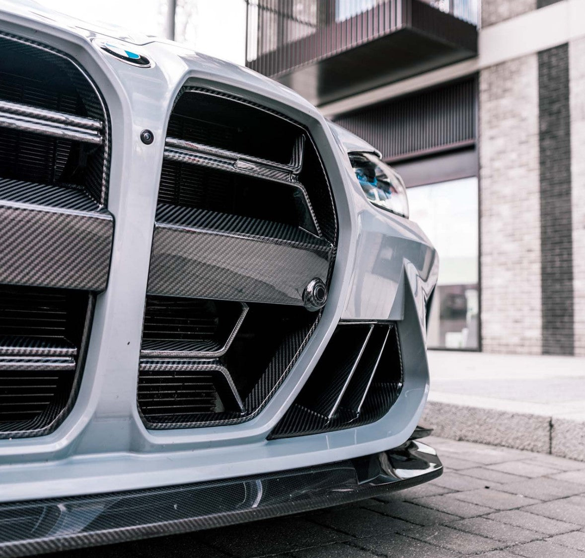 Non-ACC CSL style carbon grille installed on a gray BMW G8X, close-up of the kidney openings