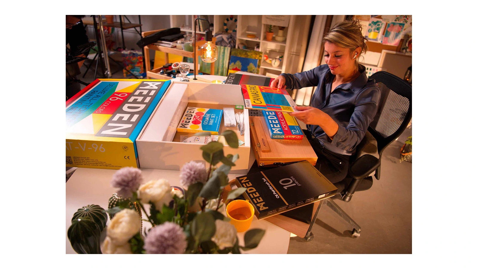 Person examining MEEDEN art materials beside an open box