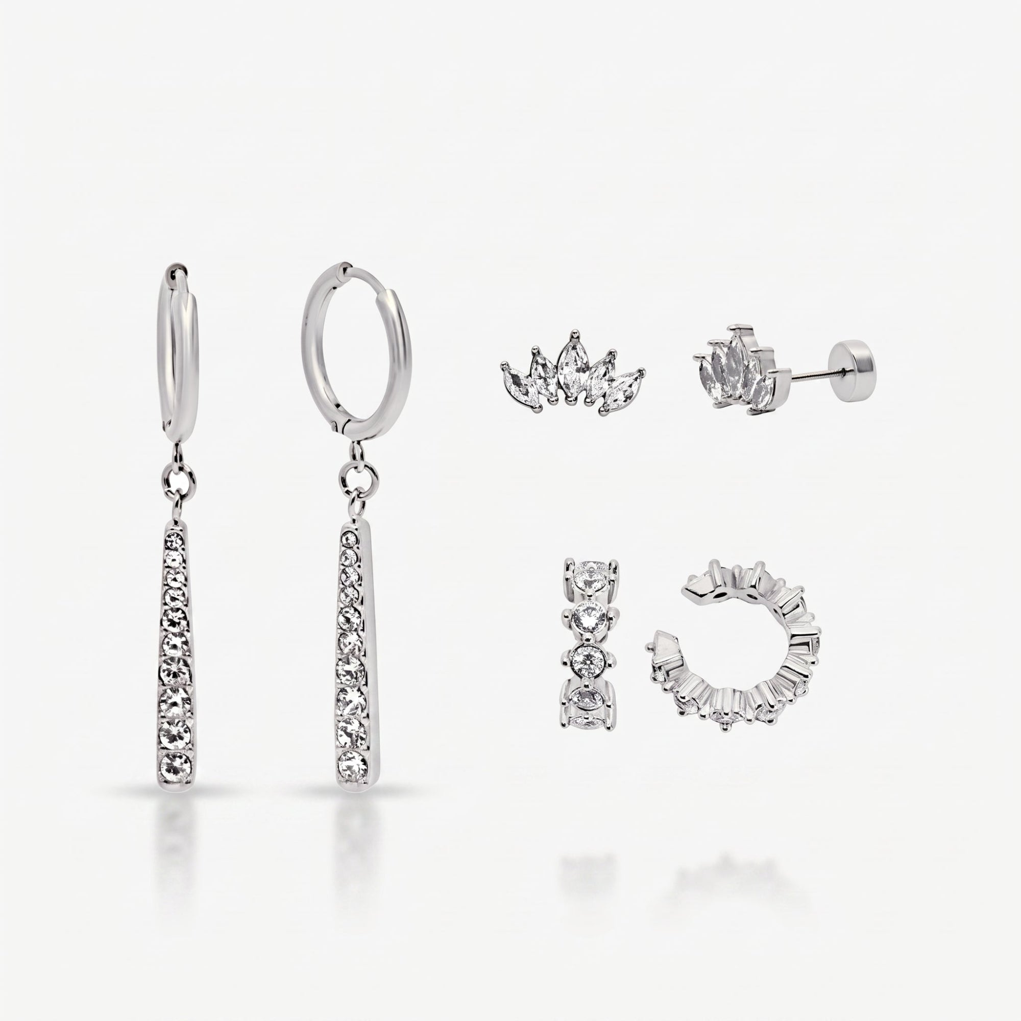 Silver Better Together set laid out: two stone-set drop hoops, two crown studs and a stone ear cuff