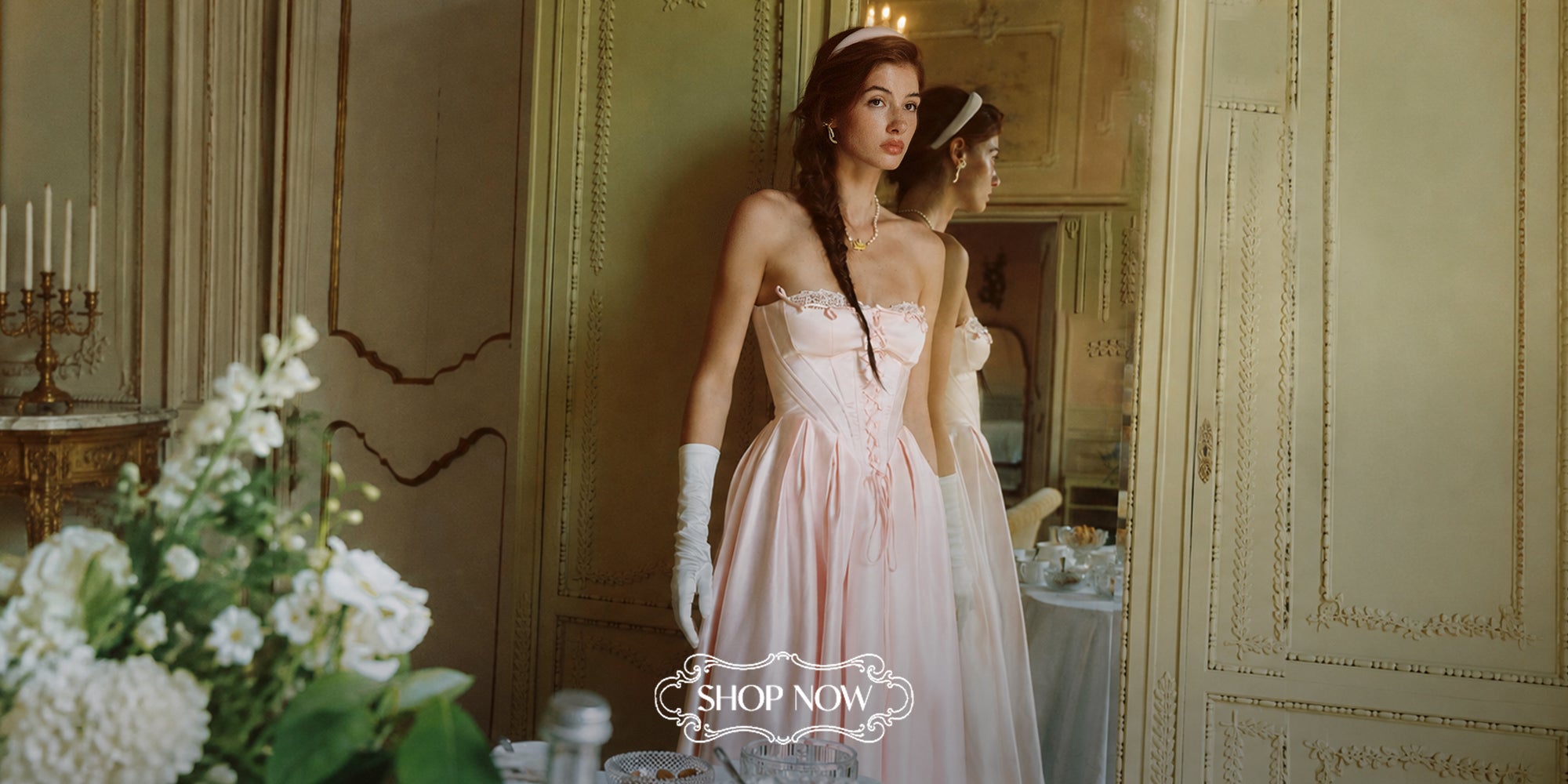 Model wearing a pink LaceMade corset gown in an elegant interior