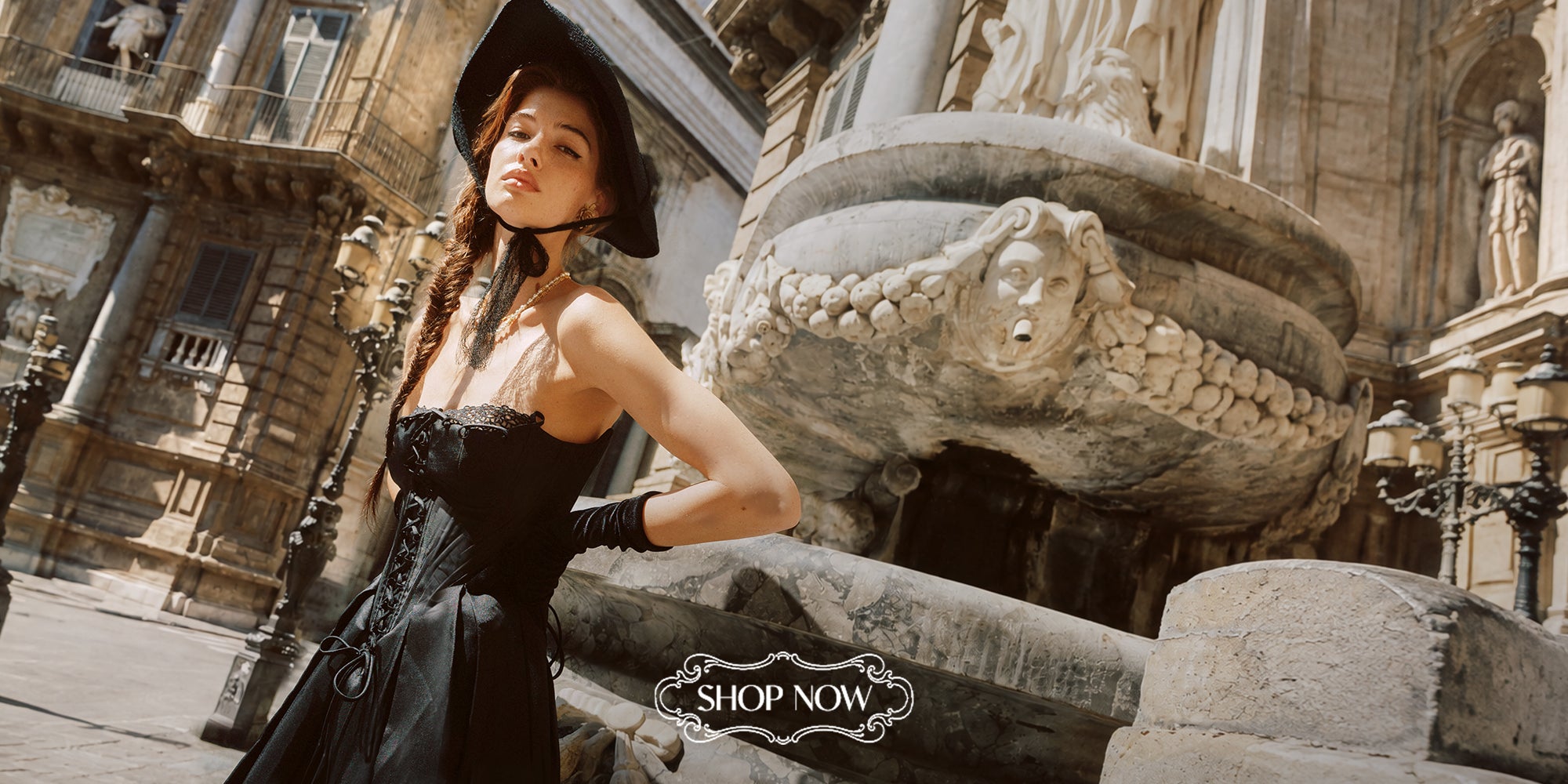 Model wearing a black LaceMade corset dress in an ornate city square