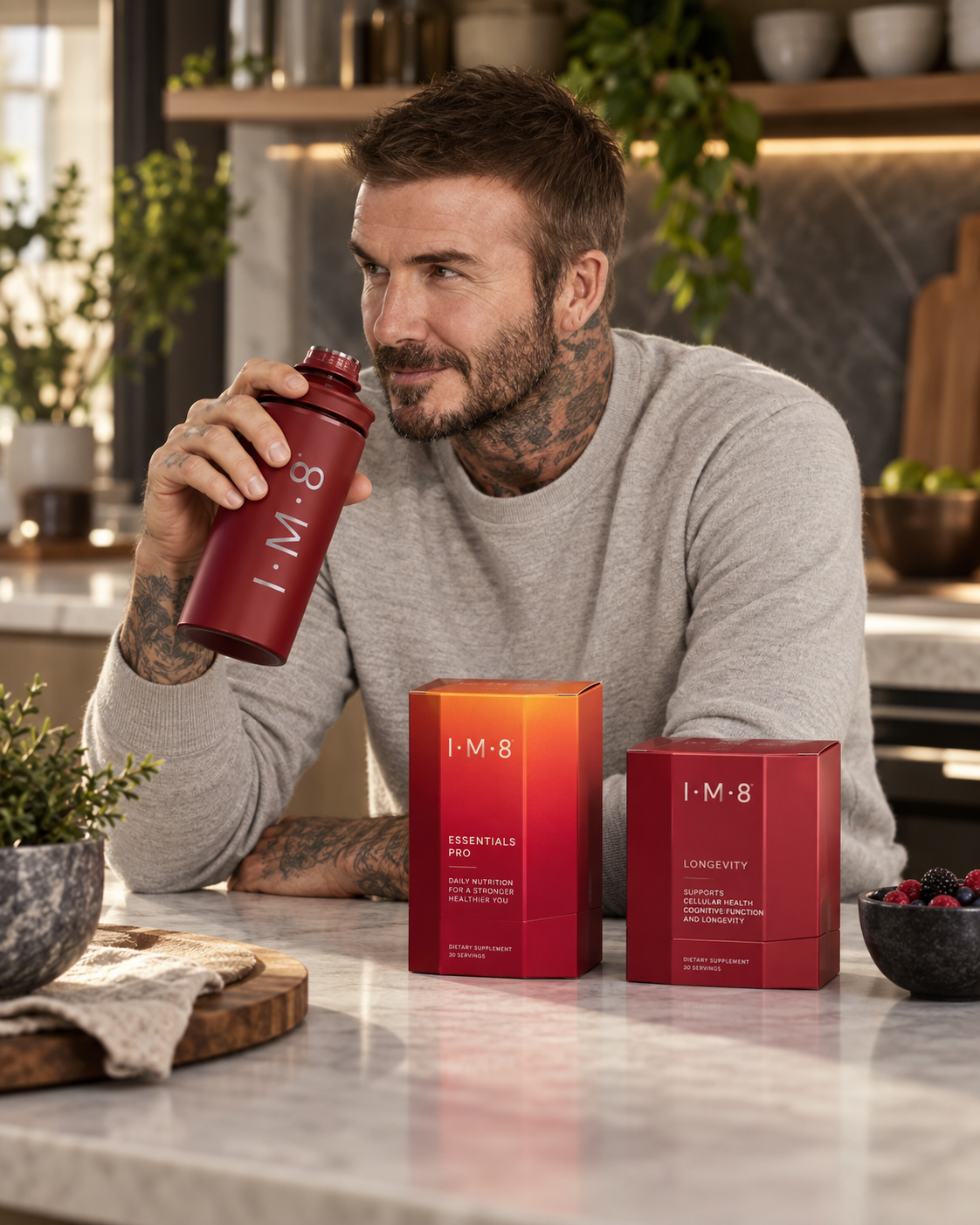 David Beckham holding an IM8 bottle beside IM8 supplement products