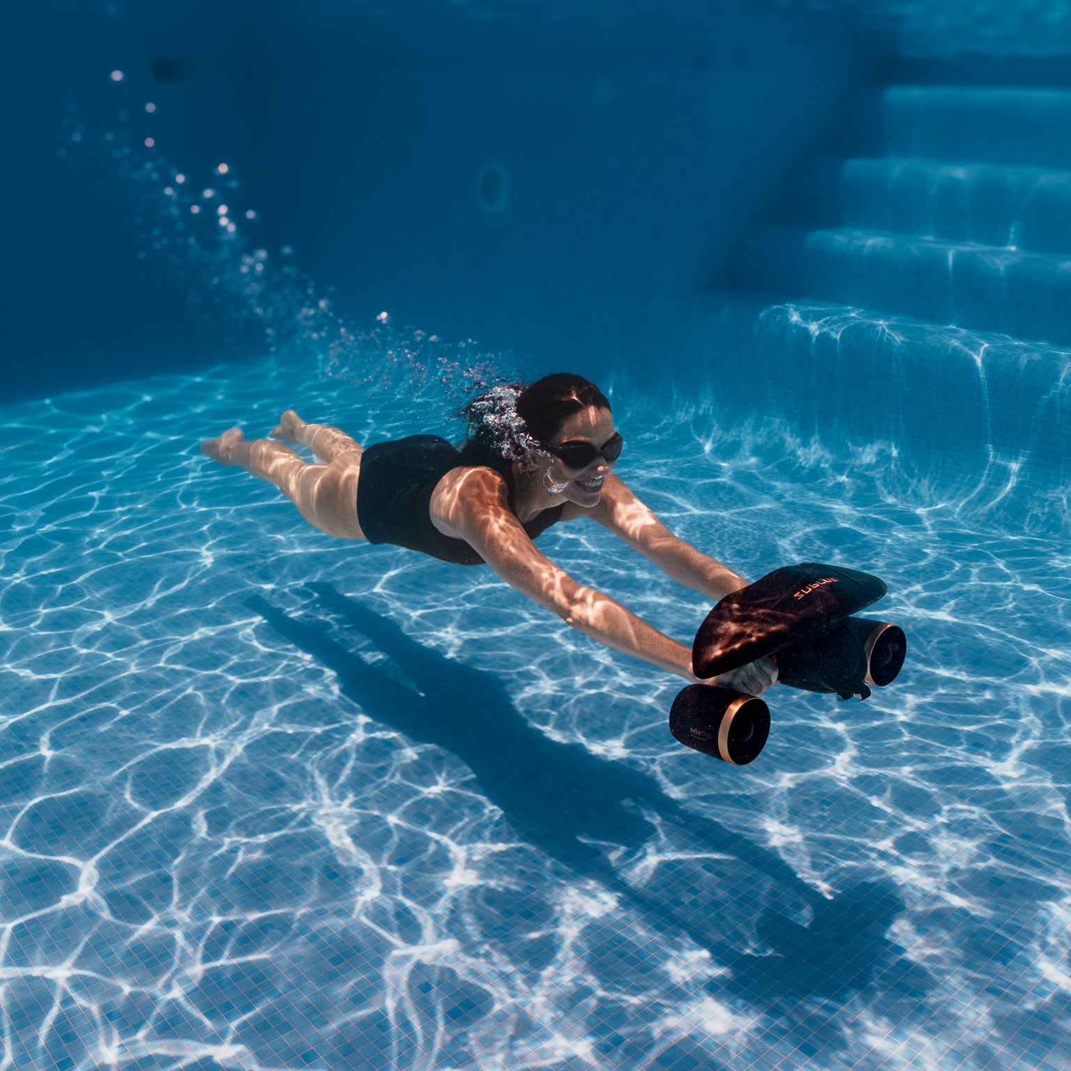 Swimmer using a black SUBLUE MixPro with gold-colored details in a pool