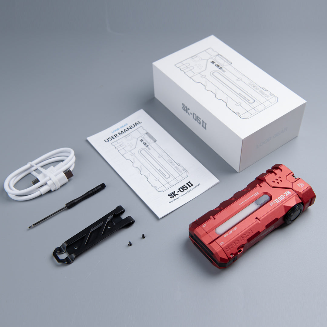 UV Red flashlight beside its cable, clip, small screwdriver, manual and box
