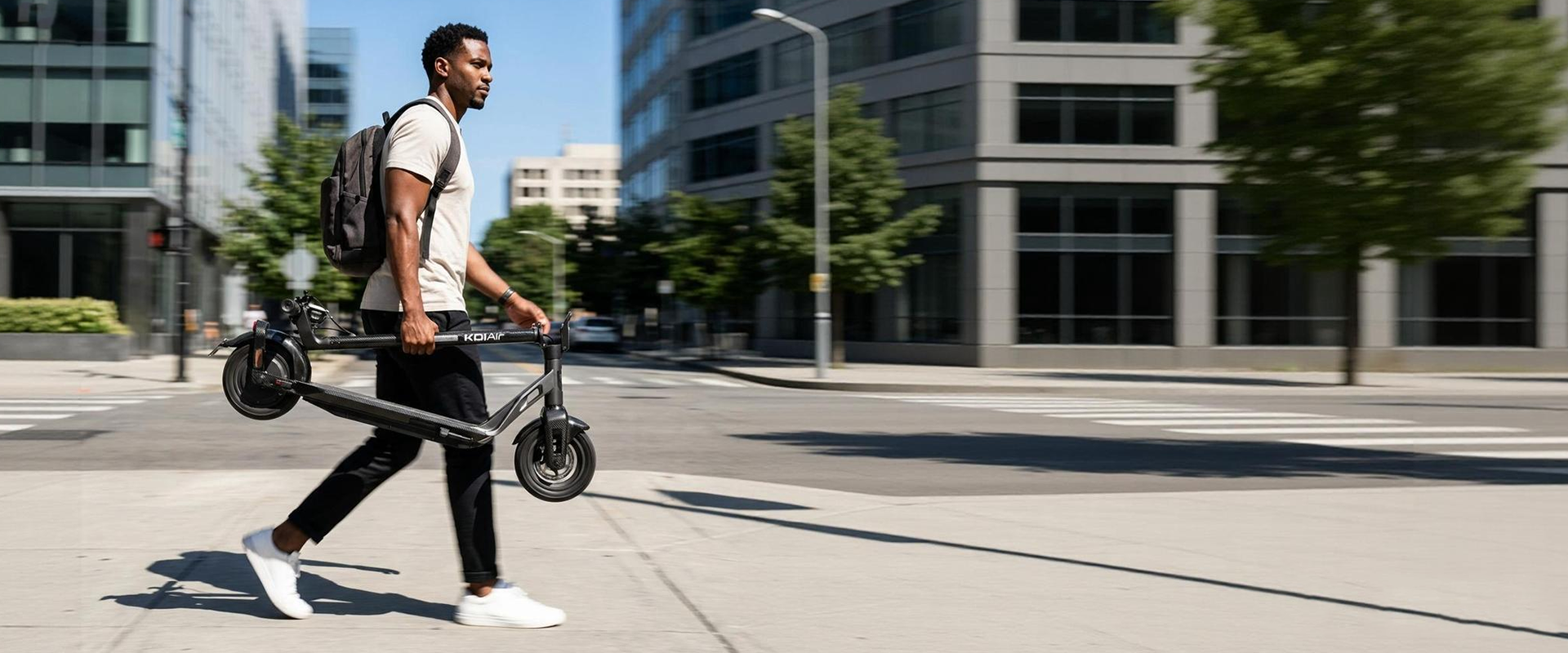 Commuter carrying a folded NIU KQi Air electric scooter